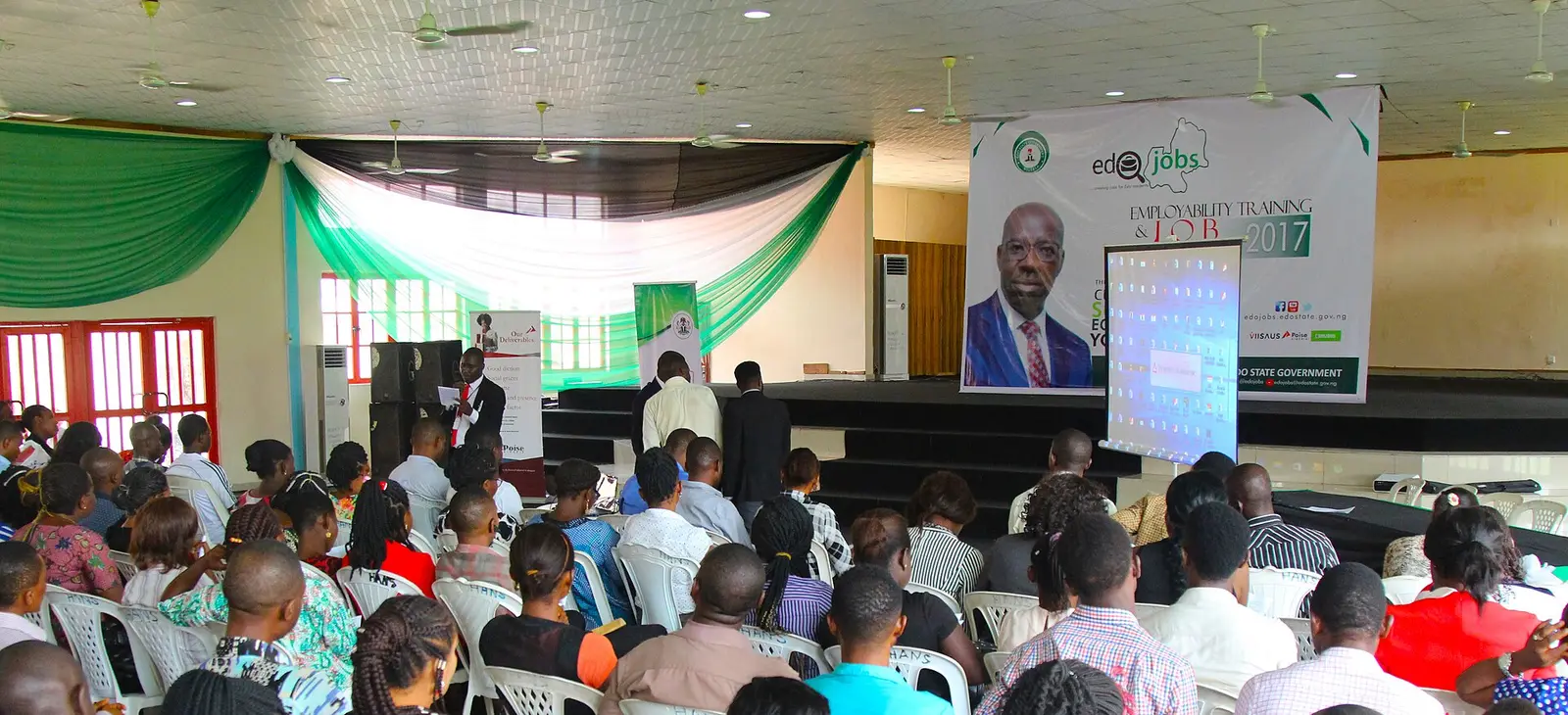 Entrepreneurs seated in a hall facing a stage and screen at an entrepreneurship forum