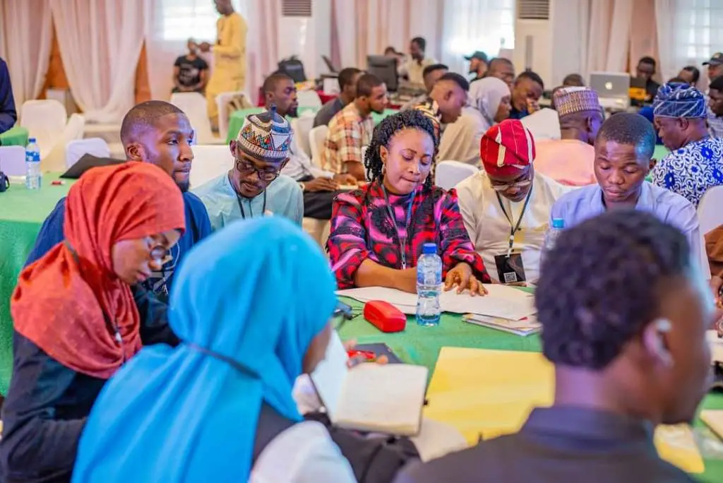 Participants working together around tables during a conference breakout session